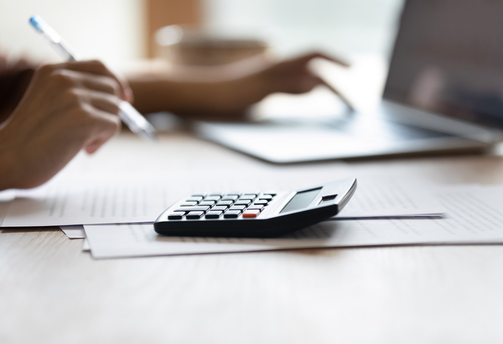 Adjuster Working at Desk With a Computer and a Calculator